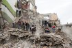 Спасатели и местные жители на месте уничтоженного бомбардировкой дома 